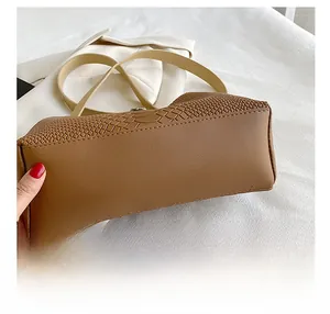 Detail showing smooth caramel leather bottom and python pattern stitching on tote bag