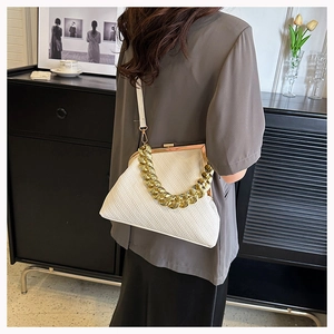 Detail of white woven shell bag featuring gold chunky chain and vintage clasp closure