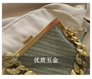 Macro shot of high-quality gold hardware and striped woven fabric on evening clutch