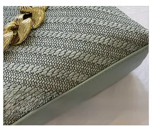 Macro detail of woven shell bag featuring mint green leather edges and gold chain
