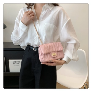 Model showcasing pink chevron quilted crossbody bag with gold chain strap and turn-lock