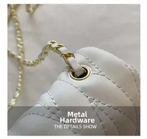 Detailed macro view of white quilted leather texture with gold metal chain strap hardware