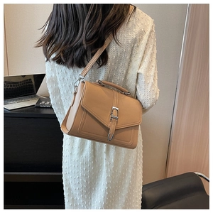 Close-up of khaki faux leather crossbody bag with silver buckle and reinforced handle