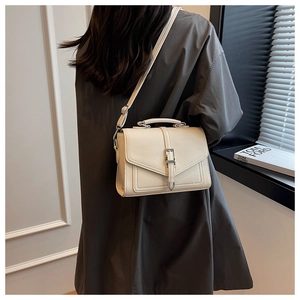 Chic cream leather square bag shown from back view on a model with a thin shoulder strap