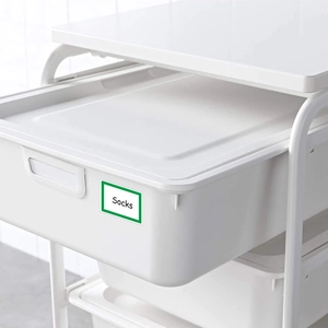 White plastic storage bin with green frame cartoon name label and Socks text for home
