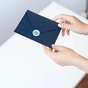 Blue Thank You stickers with smiley face applied on a dark blue envelope seal