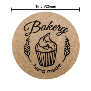 Roll of 1 inch kraft paper bakery stickers featuring handmade cupcake and grain design