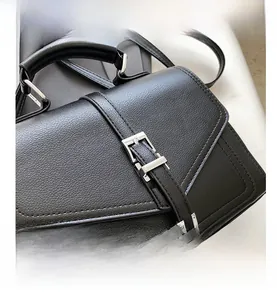 Close-up of black lychee grain leather handbag with silver metal buckle detail