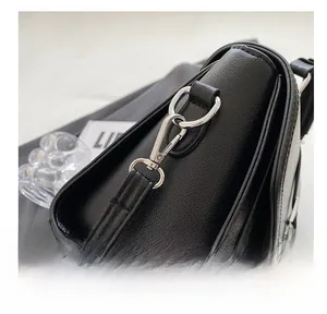 Close-up of premium black lychee leather bag texture and polished silver metal buckle
