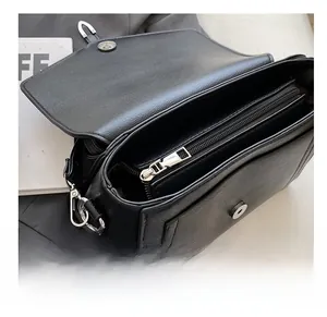 Detail shot of black litchi pattern leather handbag with silver zipper and inner pocket