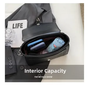 Detail of black crossbody bag interior showing spacious compartments for phone and umbrella