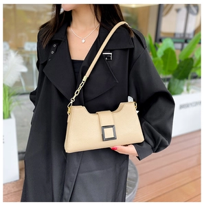Dettaglio borsa a tracolla beige in pelle martellata con fibbia e catena in metallo