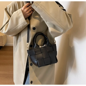 Dettaglio della borsa a mano intrecciata nera con hardware dorato e sacca interna