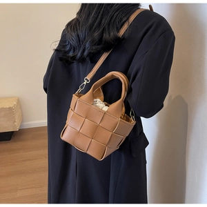 Borsa a tracolla intrecciata marrone con sacchetto interno a coulisse indossata da modella