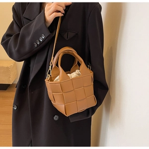 Dettaglio borsa a secchiello in pelle intrecciata marrone con fodera in tela interna