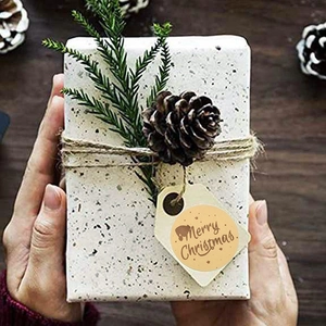 Brown Merry Christmas gift stickers on wrapped boxes with festive pine decoration