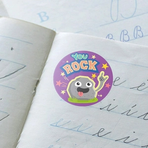 Round purple motivational sticker featuring a cartoon rock with You Rock text on paper