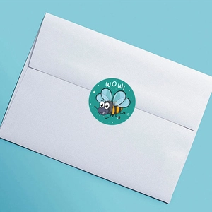 Detail of round green cat sticker with cartoon bee and WOW text on white envelope