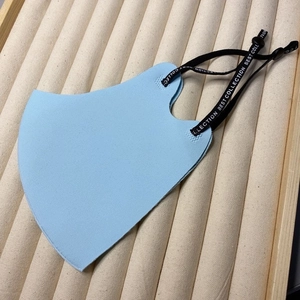 Light blue ice silk face mask with adjustable BEST COLLECTION ear loops on display