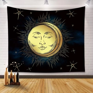 Bohemian sun and moon tapestry in black and gold hanging on a white brick wall background