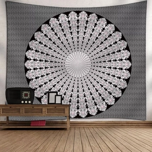 Black and white floral mandala tapestry hung above a wooden cabinet in a cozy room
