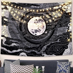 Detail view of moon phase tapestry with starry LED string lights over a sofa