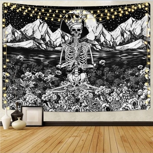 Detail of gothic skull and moon phase tapestry with soft fairy lights on a wall