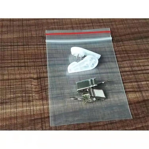Detail view of wall hanging accessory kit with clips and hooks in a clear plastic bag