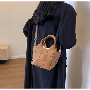 Dettaglio borsa intrecciata marrone con fodera a coulisse e tracolla rimovibile