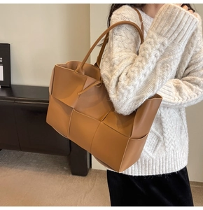 Close-up of caramel leather woven tote bag showing wide cross-weaving craft and texture
