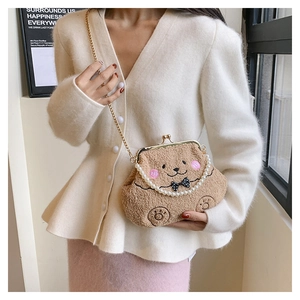 Detalle de bolso de oso de peluche marrón con asa de perlas y cierre dorado de clip
