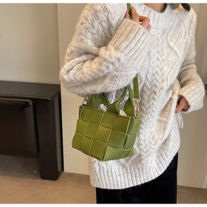 Dettaglio della borsa intrecciata verde avocado con tracolla e custodia interna a coulisse