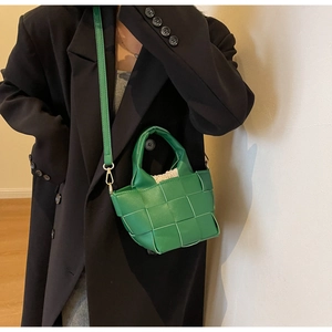 Dettaglio della borsa a tracolla intrecciata verde con texture a maglia e fodera beige