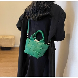 Dettaglio della borsa a tracolla intrecciata verde con fodera a coulisse e pelle