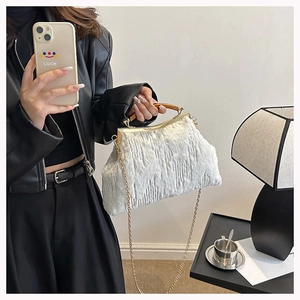 Detail of white faux fur evening bag with wooden handle and gold chain strap