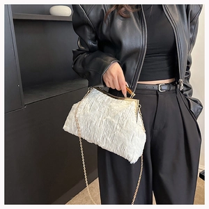 Detail of white plush evening bag with gold chain strap and tortoiseshell handle accents