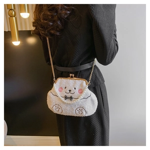 Detalle de bolso de peluche blanco con asa de perlas y cadena dorada en modelo