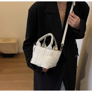 Dettaglio borsa a tracolla intrecciata bianca con ampie fasce e hardware dorato