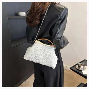 Rear view of a white plush evening bag with gold handle and chain on a female model