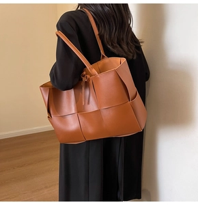 Brown woven leather tote bag shown on a model with side view and strap detail