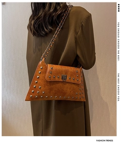 Detail view of vintage caramel brown rivet shoulder bag with silver studs and metal chain