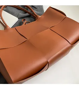 Close-up of wide-weave caramel leather tote bag showing premium craftsmanship and texture