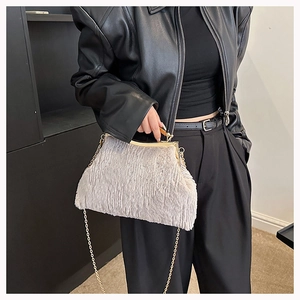 Close-up of fluffy faux fur evening bag with gold metal clasp and chain strap detail