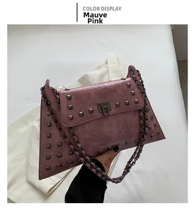 Close-up of fuchsia vintage rivet bag with metallic square studs and chain strap