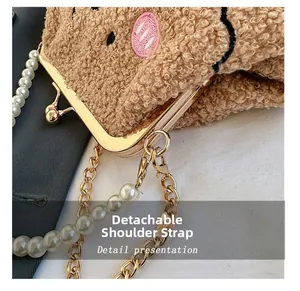 Vista de detalle del bolso de peluche con correa de perlas y cierre de clip dorado