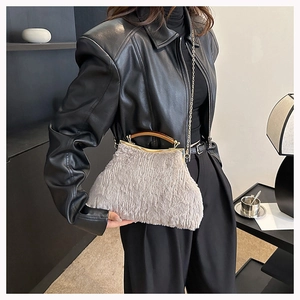 Detail of plush faux fur evening bag with vintage wood handle and gold metal frame clasp