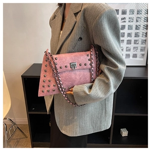 Detail of pink leather envelope bag with silver square studs and metal chain strap