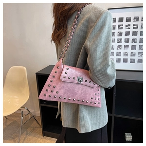 Detailed side view of pink faux leather bag featuring square metal studs and chain strap