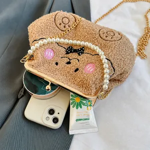 Detalle de capacidad del bolso de oso de peluche marrón con asa de perlas y cadena