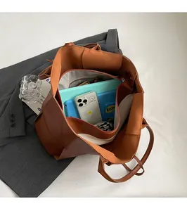 Interior view of brown woven tote bag showing large capacity with tablet and essentials